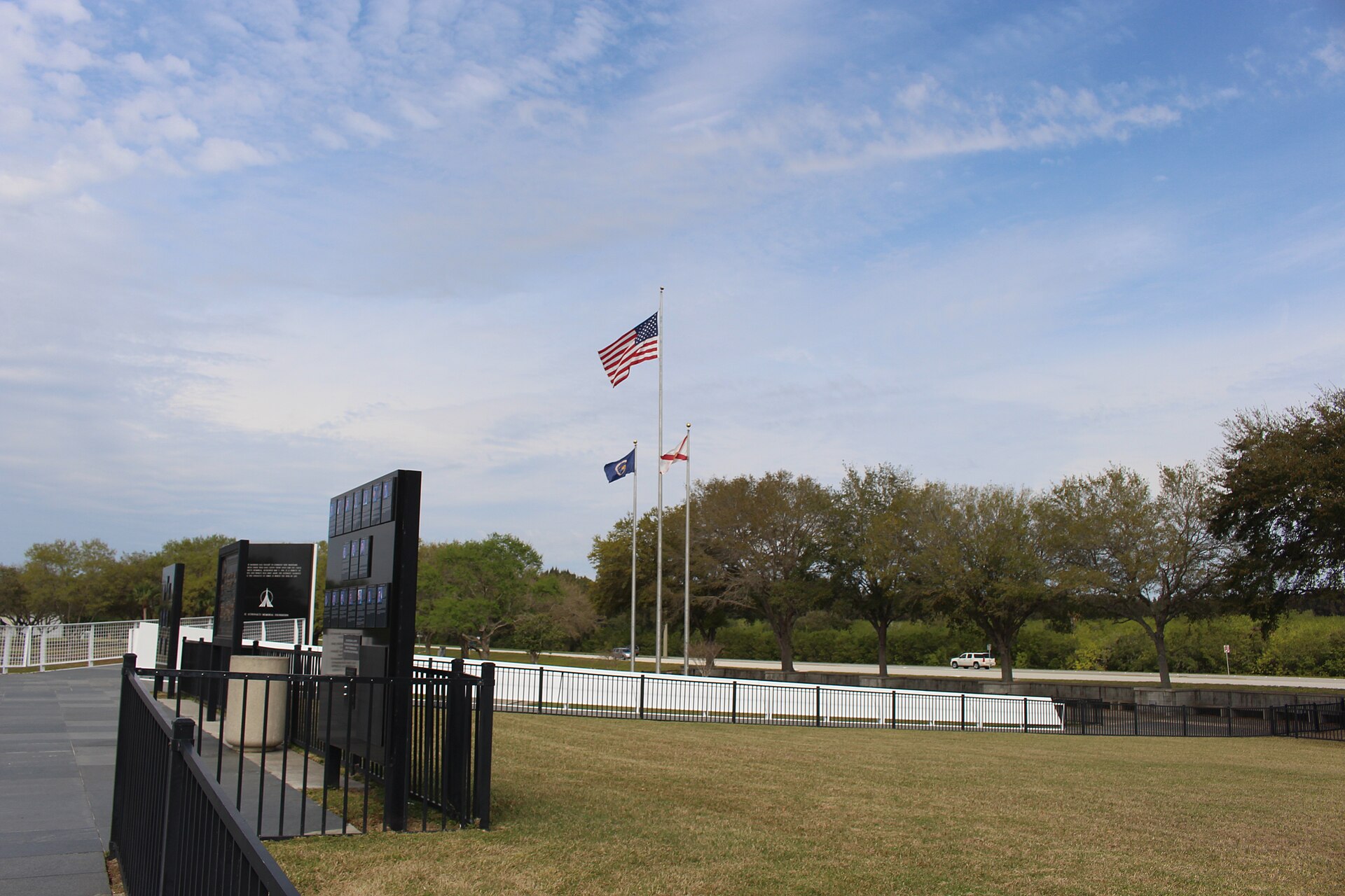 Space Mirror Memorial with American flag and Florida flag at half-staff.